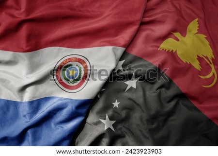big waving national colorful flag of Papua New Guinea and national flag of paraguay . macro