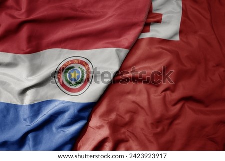 big waving national colorful flag of Tonga and national flag of paraguay . macro