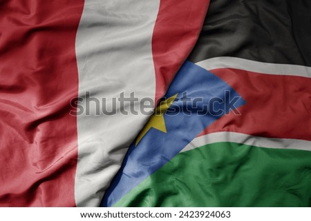 big waving national colorful flag of south sudan and national flag of peru . macro