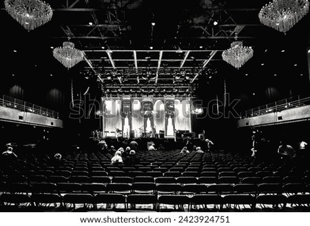 An auditorium and event venue are seen in black and white.