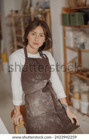 Confident entrepreneur crafts woman in pottery studio looking at camera 
