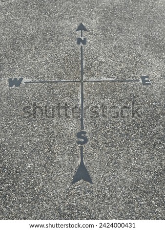 Map directions north south east west compass arrow imprint stone cement adventure