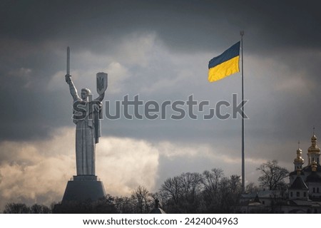 Iconic Kyiv city view. Ukrainian flag and Motherland monument on the right bank of Dnipro river Royalty-Free Stock Photo #2424004963