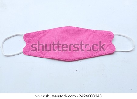 

Pink protective Medical face mask and red heart shaped isolate on a white background.Healthcare and valentines day  concept composition.Protection from coronavirus covid,love, care