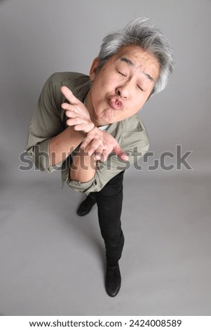 The 40s Asian man with smart casual clothes standing on the grey background.  Royalty-Free Stock Photo #2424008589