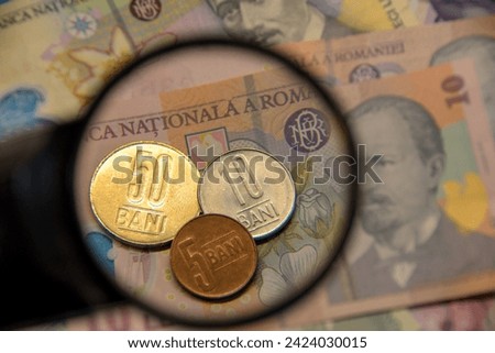 RON Romanian money,Coins over  polymer banknotes seen through a magnifying glass,selective focus Royalty-Free Stock Photo #2424030015