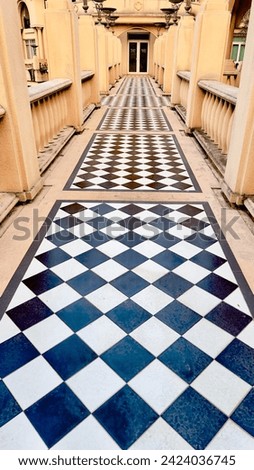 The floor of the hallway is tiled in black and white patterns.