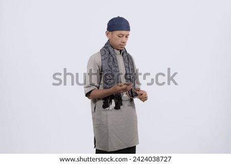 asian muslim man raising hand and praying. People religious Islamic lifestyle isolated white concept
