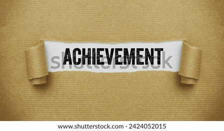 Torn paper revealing the words Achievement Royalty-Free Stock Photo #2424052015