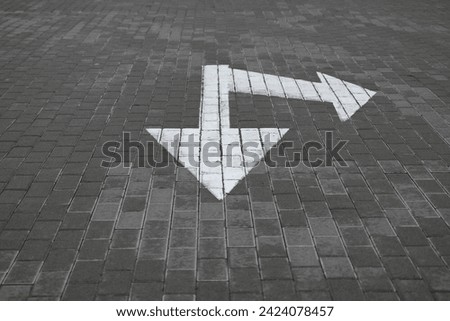 white arrow on gray asphalt, turn left, turn right, abstract white lines on asphalt, background of asphalt texture and white lines Royalty-Free Stock Photo #2424078457