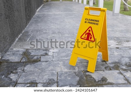 wet floor sign with water drops on wet stone floor.