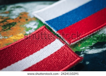 Flags of Latvia and Russia, Symbols of countries, Concept, Mutual relations, common border, Russian minority in Latvia Royalty-Free Stock Photo #2424110291