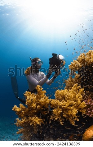 A woman is taking a picture of a coral reef