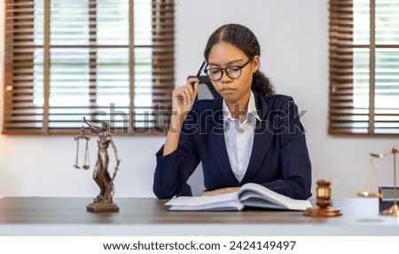 Portrait of young female Lawyer or attorney working in the office, analyzing data, reading contract documents work with law books hammer of justice Consulting lawyer concept.