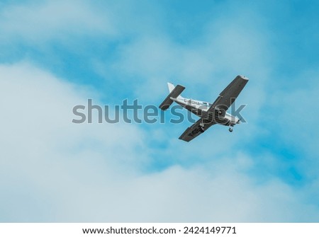 A small plane flying in the clouds Royalty-Free Stock Photo #2424149771