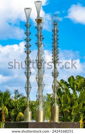 Artistic fountain well with metal figures in a tropical setting in Playa del Carmen Quintana Roo Mexico. Royalty-Free Stock Photo #2424168251