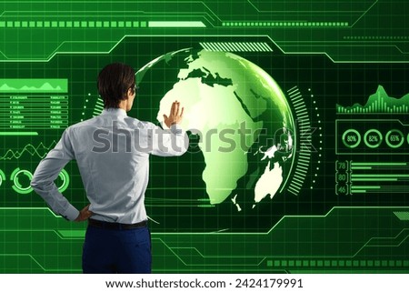 Back view of businessman using holographic screen with digital globe interface and business chart on blurry green background. HUD, international stock and future monitor concept Royalty-Free Stock Photo #2424179991