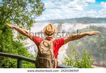 Iguazu Falls, Brazil - Traveler man with raised arms watching Iguacu waterFalls in Brasil and Argentina Royalty-Free Stock Photo #2424186969
