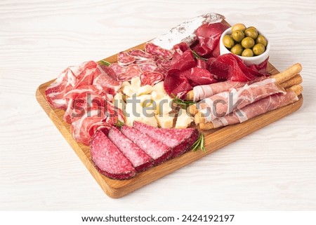 Charcuterie board. Antipasti appetizers of meat and cheese platter with salami, prosciutto crudo or jamon and olives Royalty-Free Stock Photo #2424192197