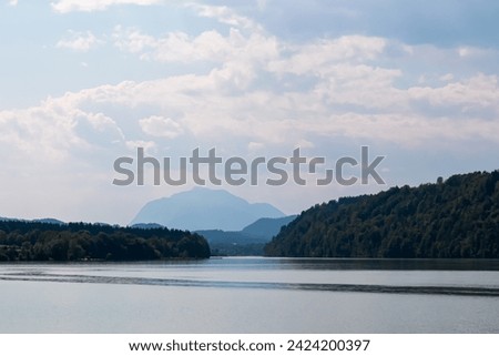 Idyllic river Drava with with scenic view of untamed mountain peaks of Karawanks, Feistritz im Rosental, Carinthia, Austria. Looking at majestic Dobratsch summit in summer. Hiking in Austrian Alps Royalty-Free Stock Photo #2424200397