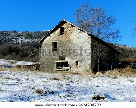 Old mountain sheepfold with snow and blue sky  Royalty-Free Stock Photo #2424204739