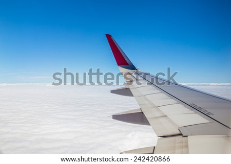 Aircraft wing on the clouds,flying background Royalty-Free Stock Photo #242420866
