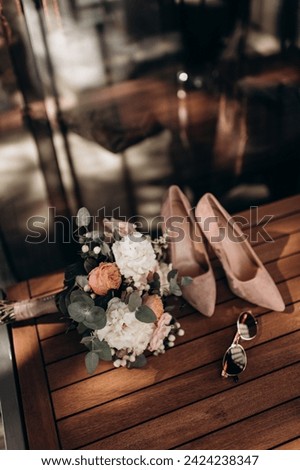 A modern composition of elegant wedding accessories for an attractive bride. Wedding rings, wedding bouquets, bottle of perfume, jewelry with sharp light Royalty-Free Stock Photo #2424238347