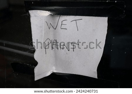 A hand written sign warning of wet paint