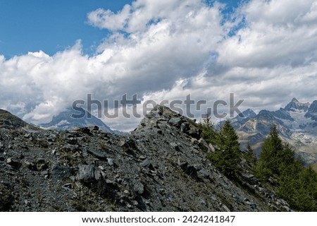 Mound of rocks and gravel foregrounding the majestic Matterhorn, framed by the Alps under a brooding sky.