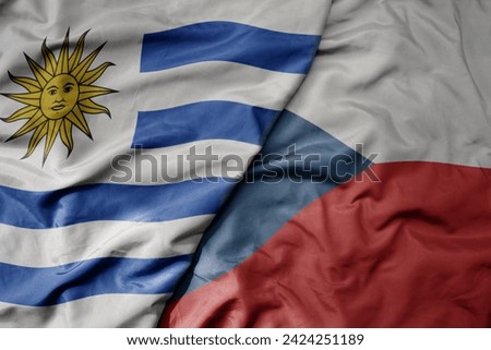 big waving national colorful flag of czech republic and national flag of uruguay . macro