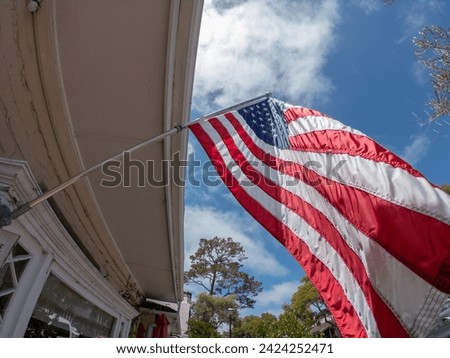 US American flag waving in the wind with a beautiful blue sky with white clouds in the background, Carmel-by-the-Sea, Monterey County, California, United States.