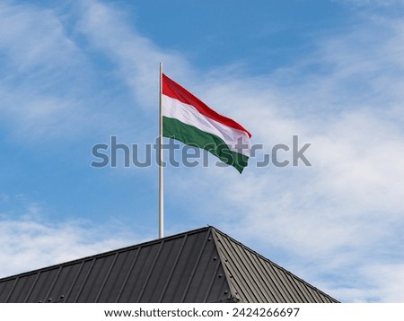 Hungarian flag on a government building rooftop. Symbol of the country Hungary in Europe and sign for an international partnership.