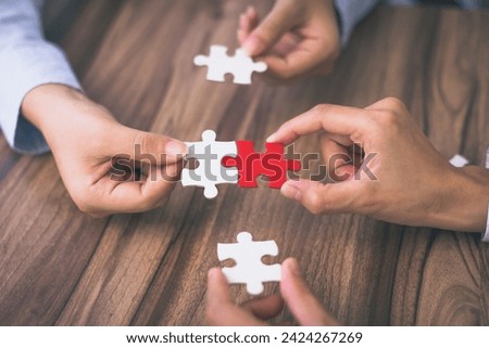 Hand put the last piece of jigsaw puzzle to complete the mission. Concept of connecting jigsaw pieces, problem solving, teamwork and success.
