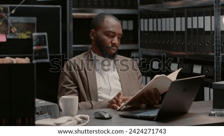 Male police detective searching forensic evidence in crime case files, using archived information. Law agent reading witness statements in reports, examining clues after research.