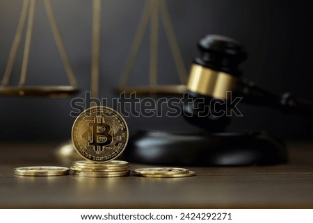 Bitcoin Crypto Regulation And Law. Cryptocurrency laws. Bitcoins and a wooden gavel with a golden scale on the table. Cryptocurrency Legislation and Tax Laws are regulated by the government. Royalty-Free Stock Photo #2424292271