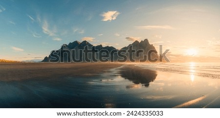 Panorama view of golden sunrise on Vestrahorn mountain with black sand beach in summer at Stokksnes peninsula, Iceland Royalty-Free Stock Photo #2424335033