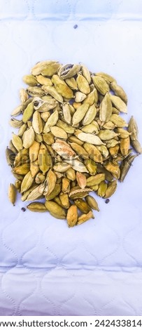 The picture of cardamom depicts small, light green pods with a papery outer shell. Inside, there are small black seeds.They have a distinct, warm, and slightly citrusy flavor profile.