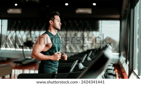 Young Asian Man Running on Treadmill - Fitness Gym Exercise Royalty-Free Stock Photo #2424341441