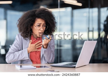 Asmathic executive director keeping hand on chest and opening mouth for using inhaler by desktop with computer. Unhealthy female suffering from breathing difficulty and using medicine in workplace. Royalty-Free Stock Photo #2424360887
