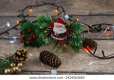 New Year and Christmas decorations on a wooden table. Santa Claus, garland, cones, branches. Vintage style. Cozy home interior in brown tones.