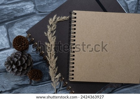 Notebooks, cones, stones on a wooden table top view. Workspace, artist's creative workshop. Cozy home interior in brown tones.