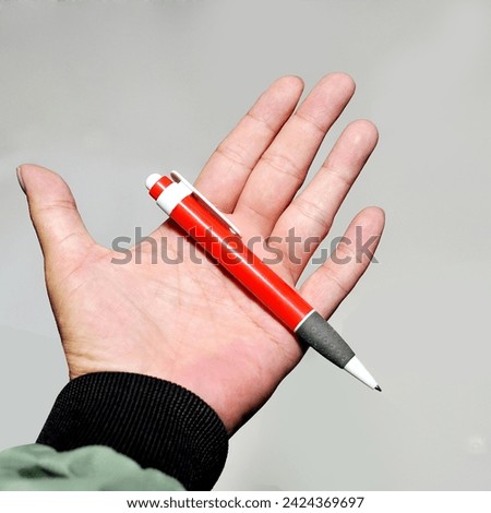 pen, hand holding a red pen, office objects on white background