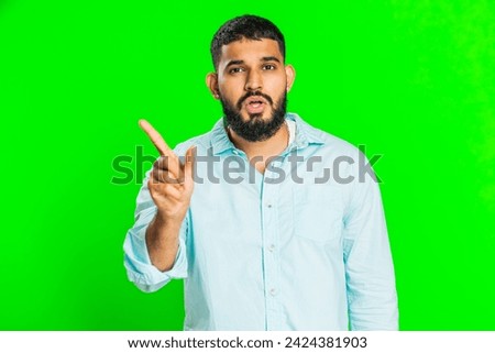 Indian young man shakes finger and saying no, be careful, scolding and giving advice to avoid danger mistake, disapproval sign, disagree, dislike. Arabian guy isolated on green chroma key background