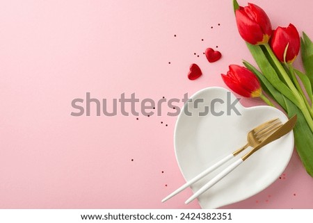 Picture-perfect 8 March date tableau, top view perspective of table adornment, heart plate, high-end fork and knife, glitters, hearts, bunch of tulips on soft pink field, leaving margin for text or ad