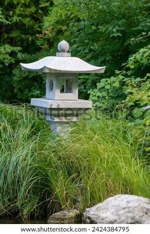 A Japanese standing lamp in the interior of the park. Standing street stone lamp in the park
