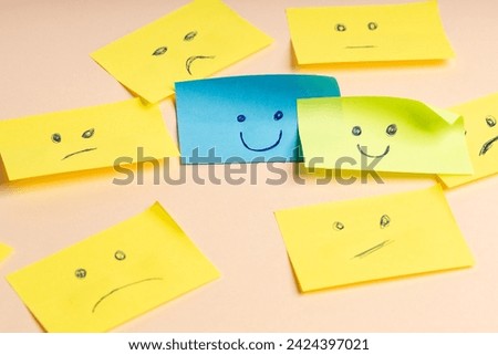 Colorful cards with drawn faces expressing emotions of satisfaction and anger