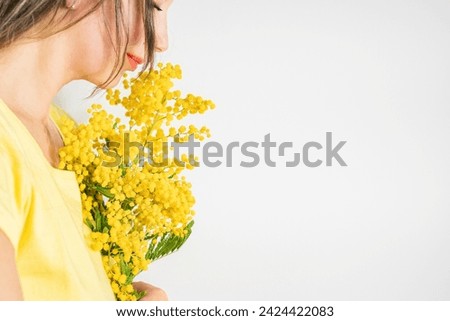 Beautiful young woman with mimosa flowers on white background. Copy space Royalty-Free Stock Photo #2424422083