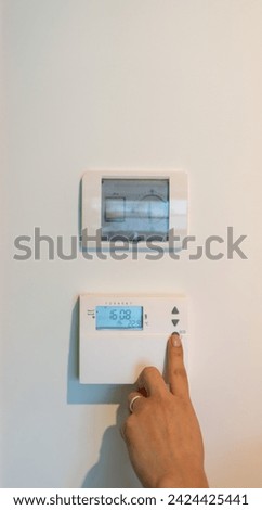 finger pulsing digital heating control panel raising house temperature, air conditioner, wireless thermostat