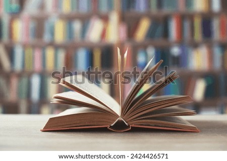 open book with a stack of books on the wooden table. back to school. copy space for text or text