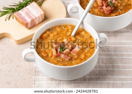 Creamy yellow split pea soup with smoked bacon, ham. Homemade comfort food. Royalty-Free Stock Photo #2424428781